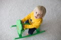 Little cute toddler boy, playing with rocking frog swing at home Royalty Free Stock Photo
