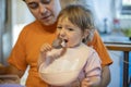 Little cute toddler girl eating ice cream popsicle sitting on daddy`s lap Royalty Free Stock Photo