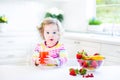 Little cute toddler girl having breakfast drinking juice Royalty Free Stock Photo