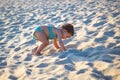 Little cute toddler kid plays and climb the sand of the beach Royalty Free Stock Photo