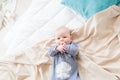 Little cute toddler is lying at home on the bed