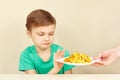 Little cute unhappy boy refuses to eat french fries Royalty Free Stock Photo