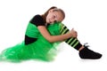 Little dancer in green tutu skirt sitting