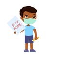 Little dark skin boy with face mask holding paper sheet with `STAY HOME` sign.