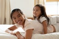 Little daughter and asian mother playing while lying on bed Royalty Free Stock Photo