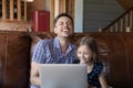 Little daughter and caring father watching funny video on laptop Royalty Free Stock Photo