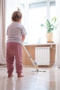 little daughter cleaning in the house, child dusting, Cute little helper girl washing floor with mop, happy family Royalty Free Stock Photo