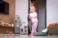 little daughter cleaning in the house, child dusting, Cute little helper girl washing floor with mop, happy family Royalty Free Stock Photo