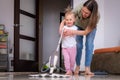 little daughter cleaning in the house, child dusting, Cute little helper girl washing floor with mop, happy family Royalty Free Stock Photo