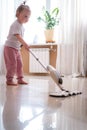 little daughter cleaning in the house, child dusting, Cute little helper girl washing floor with mop, happy family Royalty Free Stock Photo