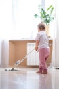 little daughter cleaning in the house, child dusting, Cute little helper girl washing floor with mop, happy family Royalty Free Stock Photo