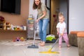 little daughter cleaning in the house, child dusting, Cute little helper girl washing floor with mop, happy family Royalty Free Stock Photo