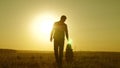 Little daughter and dad walk around field holding hands. child holds father`s hand. dad and baby are resting in the park Royalty Free Stock Photo