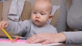 A little daughter enthusiastically drawings with colored pencils on sheet of paper, little girl next to her mother. Kid Royalty Free Stock Photo