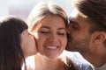 Little daughter and father kissing smiling mother wife on cheeks Royalty Free Stock Photo