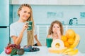 Little daughter and her happy mother drinks green smoothie. Natural antioxidant. Healthy Green food. Mother and daughter Royalty Free Stock Photo