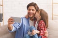 Little daughter kissing daddy while taking selfie together