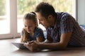 Little daughter and loving father reading book on tablet indoors Royalty Free Stock Photo