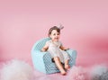 Little daughter sitting on an infantine armchair Royalty Free Stock Photo