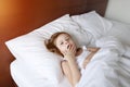 Little daughter yawn, feel sleepy at bed home on sunny good morning Royalty Free Stock Photo
