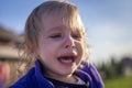 Little disheveled girl crying outdoors Royalty Free Stock Photo