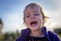 Little disheveled girl crying outdoors Royalty Free Stock Photo