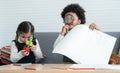 Little diverse kids boy and girl ,African and Caucasian, playing drawing on book, holding magnifying glass and microscope