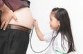 Little doctor check heart by stethoscope to obese asian man