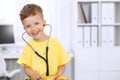 Little doctor examining a ntoy bear patient by stethoscope Royalty Free Stock Photo