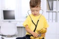 Little doctor examining a ntoy bear patient by stethoscope Royalty Free Stock Photo