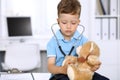 Little doctor examining a ntoy bear patient by stethoscope Royalty Free Stock Photo