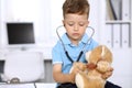 Little doctor examining a ntoy bear patient by stethoscope Royalty Free Stock Photo