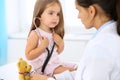 Little doctor examining a ntoy bear patient by stethoscope