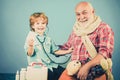 Little doctor grinning while showing tablet to old grandfather. Old man taking a pill. Little doctor. Grandfather and Royalty Free Stock Photo