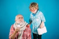 Little doctor ready to examine. Charming little boy examining a cheek of his grandfather. Old man with scarf holding a