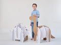 Little dreamer boy playing with a cardboard dinosaurs Brontosaurus and Ankylosaurus. Childhood. Fantasy, imagination.