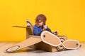 Little dreamer girl playing with a cardboard airplane. Childhood. Fantasy, imagination. Royalty Free Stock Photo