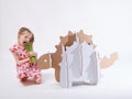 Little dreamer girl playing with a cardboard dinosaur Ankylosaurus. Childhood. Fantasy, imagination.