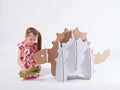 Little dreamer girl playing with a cardboard dinosaur Ankylosaurus. Childhood. Fantasy, imagination.