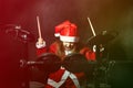 Little drummer disguised as Santa Claus playing the electronic drum kit