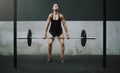 With a little effort you can build ultimate power. a young woman exercising with a barbell in a gym.