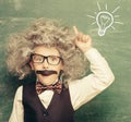 Little Einstein  against chalkboard. Royalty Free Stock Photo