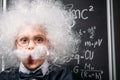 little Einstein in eyeglasses with theory of relativity Royalty Free Stock Photo