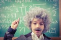 Little Einstein having an idea in front of chalkboard Royalty Free Stock Photo