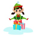 Little elf girl jumps over gift boxes. The child is happy and dressed in a traditional elf costume. Royalty Free Stock Photo