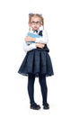 Little emotional girl in a school uniform with glasses stands with a book pouting cheeks, isolated on white background.