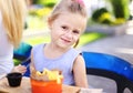 Little european girl eating rench fries with sauce at street cafe outside. Royalty Free Stock Photo