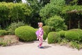 Little european girl in japanese kimono in japanese little garden. Japanese kimno on european girl