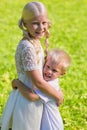 Little excited boy hugging his sister strongly