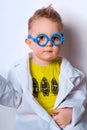 Little explorer. Boy plays scientist. Funny child with blue glasses. Cute, colorful photo. Kid portrait in doctor or